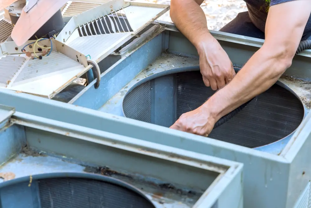 HVAC technician replacing an air conditioner capacitor that keeps blowing during a Corona heatwave
